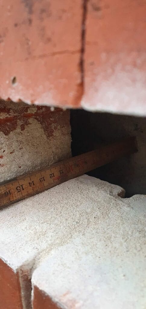 Trælineal mellem mursten og betonoverflade