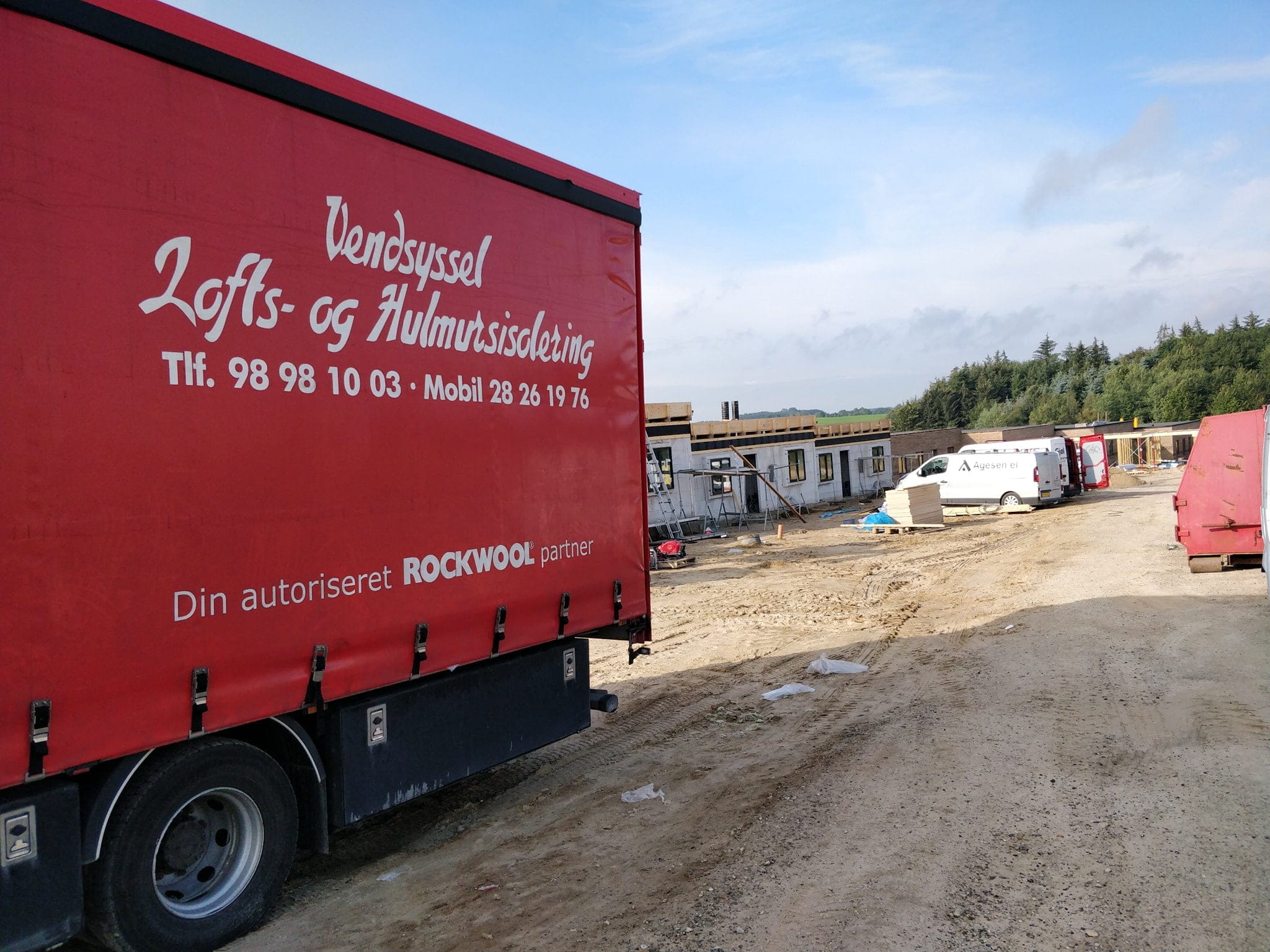 Byggeplads med isoleringsfirma lastbil og varevogne